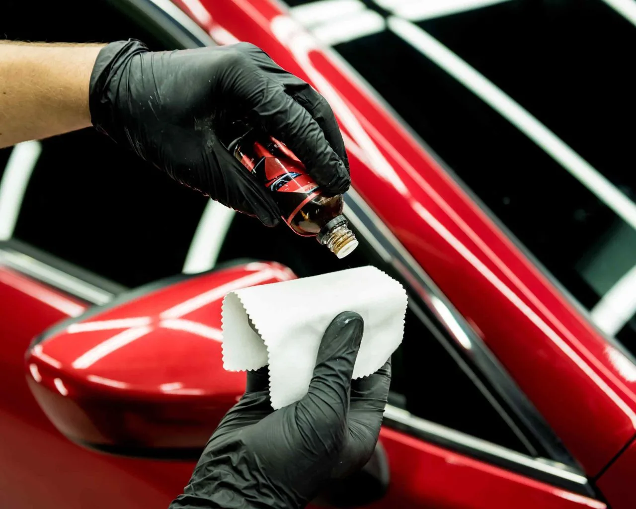 Technician applying ceramic coating to a vehicle panel